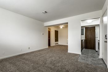 A spacious room with a carpeted floor and white walls.
